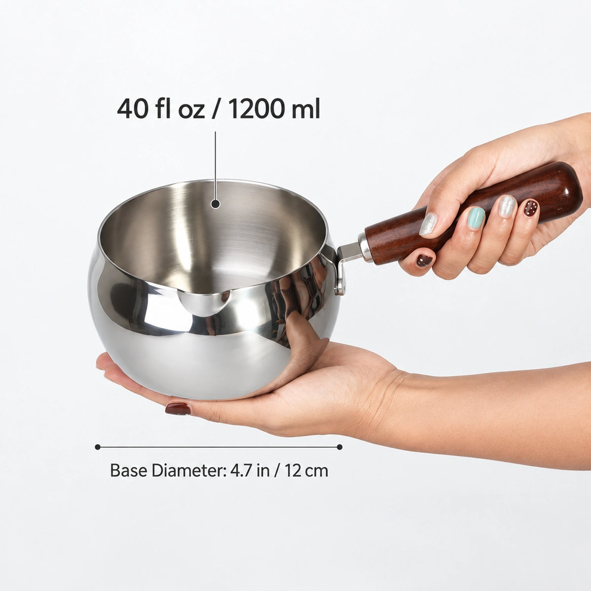 40 oz stainless steel milk pan with wooden handle shown in hand for size comparison