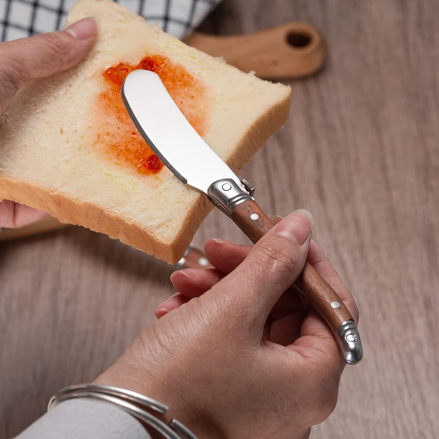 IMEEA butter spreader spreading jam on bread, showing its use for everyday food preparation