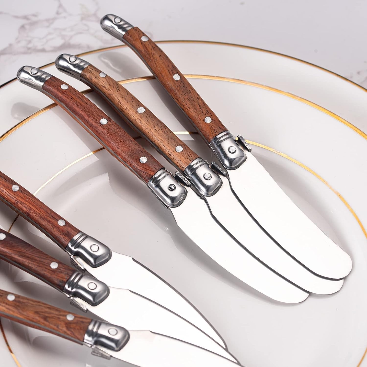IMEEA butter spreader set close-up displayed on a plate, showing the stainless steel blades and wood handles