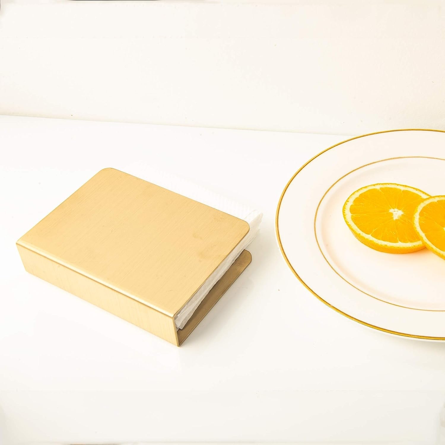 Morden IMEEA gold stainless steel cocktail napkin holder lying flat on a table