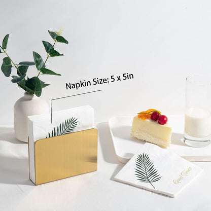 IMEEA gold stainless steel cocktail napkin holder with 5 x 5 inch beverage napkins beside cake and milk