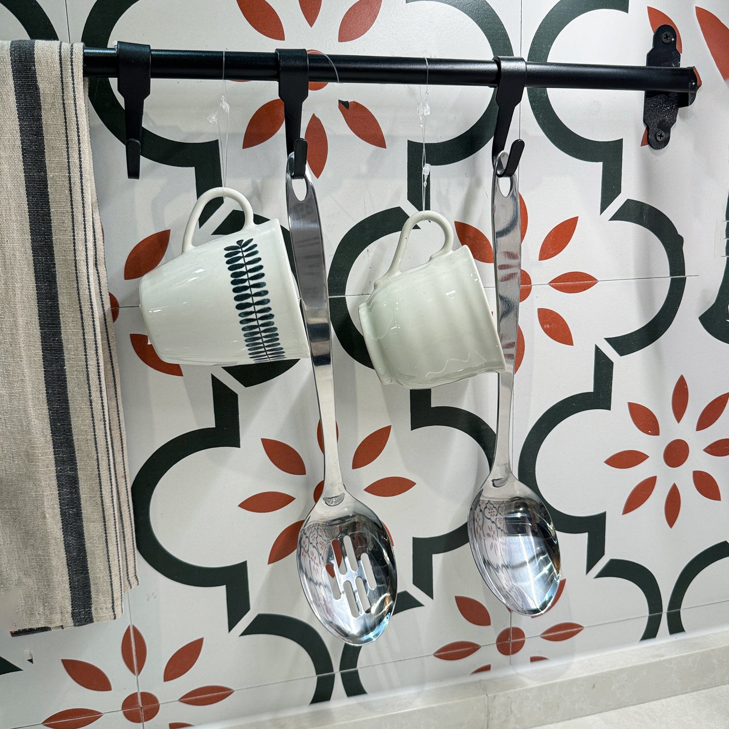 IMEEA stainless steel serving spoons hanging on a kitchen rack with built-in hanging loops for easy storage