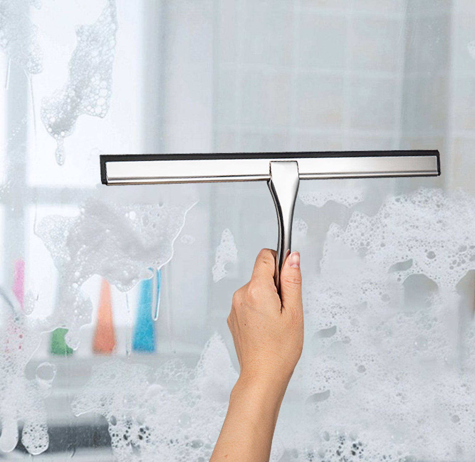 Stainless Steel Shower Squeegee wiping water droplets from a bathroom glass door for easy cleaning