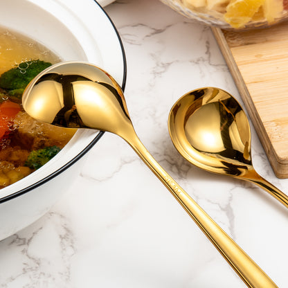 Gold Sauce Ladle displayed next to a soup bowl with a polished stainless steel finish