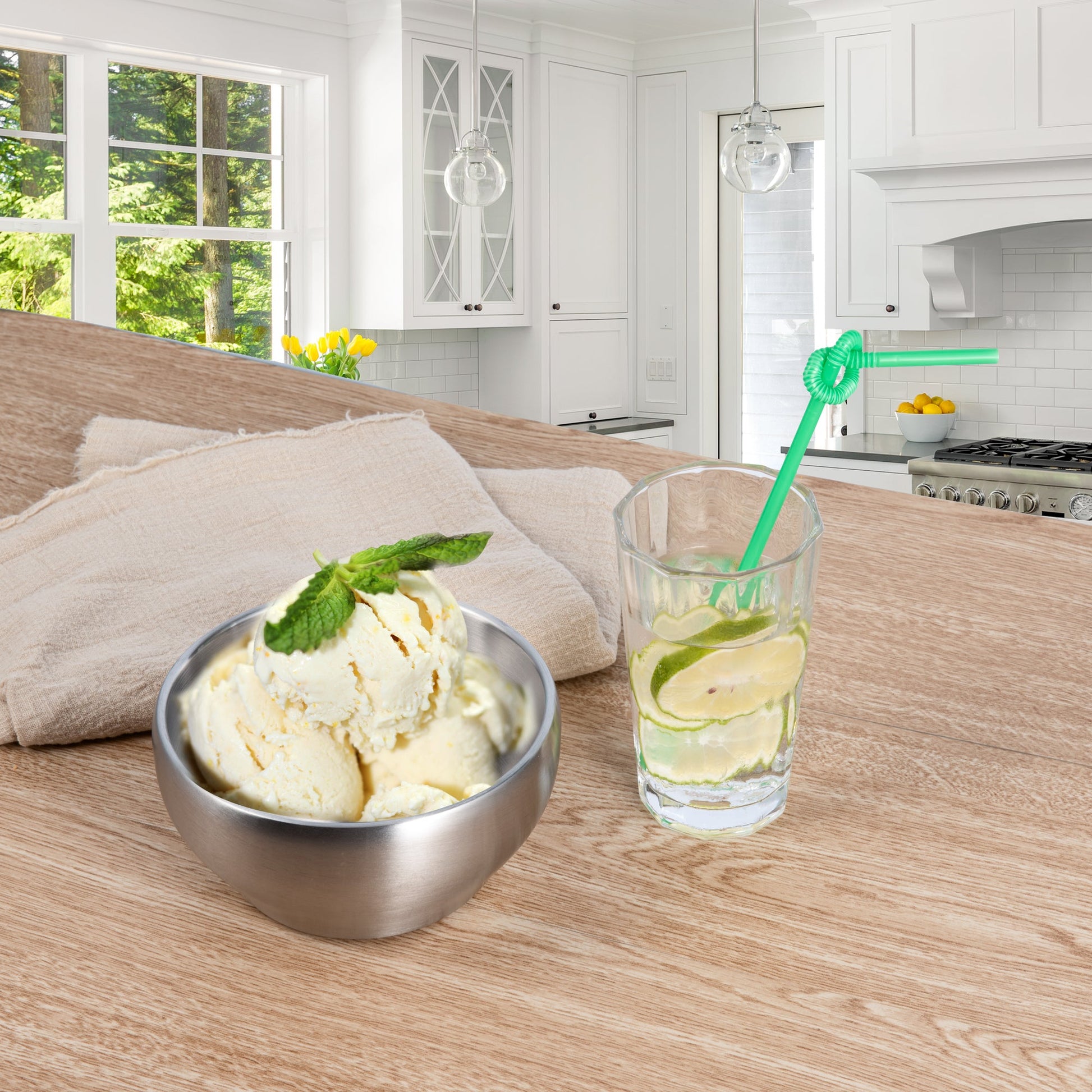 Stainless steel ice cream bowl filled with ice cream and a drink on a dining table, perfect for refreshing summer treats