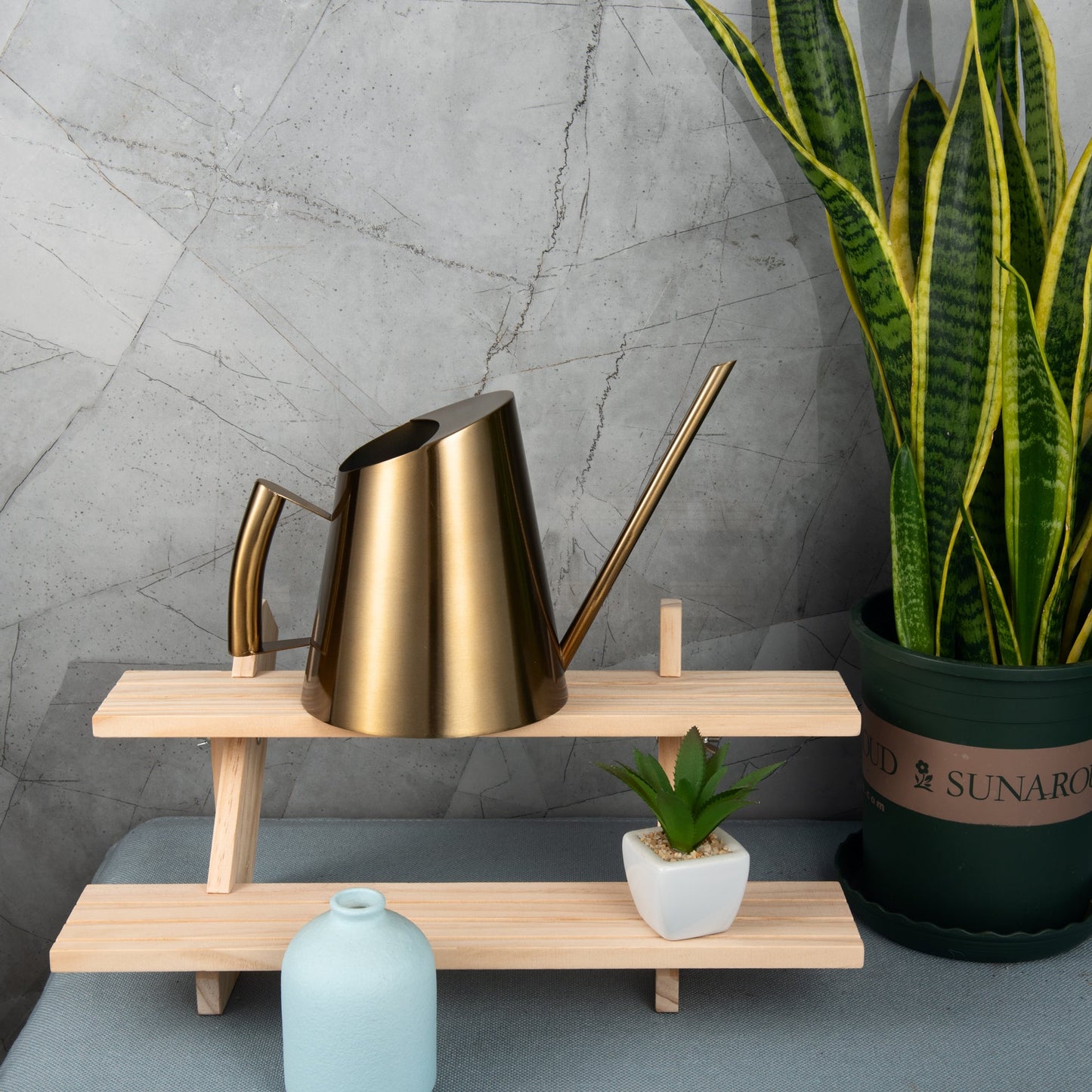 Precision IMEEA brass finish stainless steel watering can with a long spout on a wooden tiered shelf