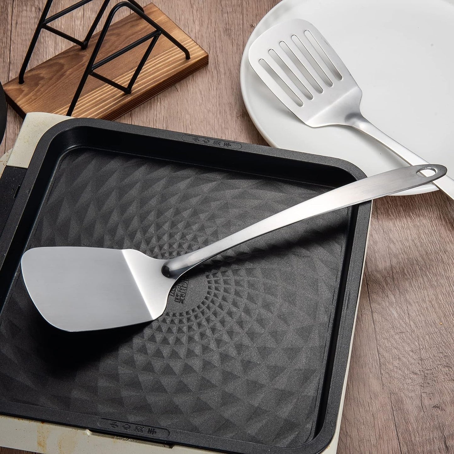 Stainless Steel Kitchen Spatula Set 13.5 inch placed on a pan, showcasing its sleek one-piece design and durable stainless steel construction
