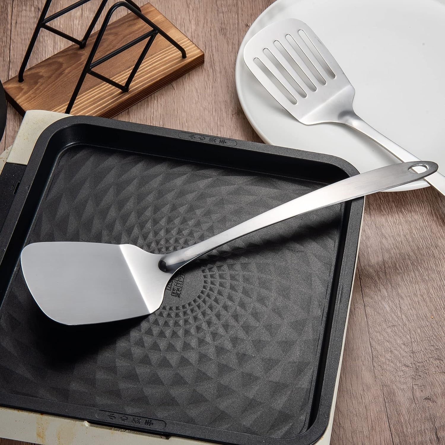Stainless Steel Kitchen Spatula Set 13.5 inch placed on a pan, showcasing its sleek one-piece design and durable stainless steel construction