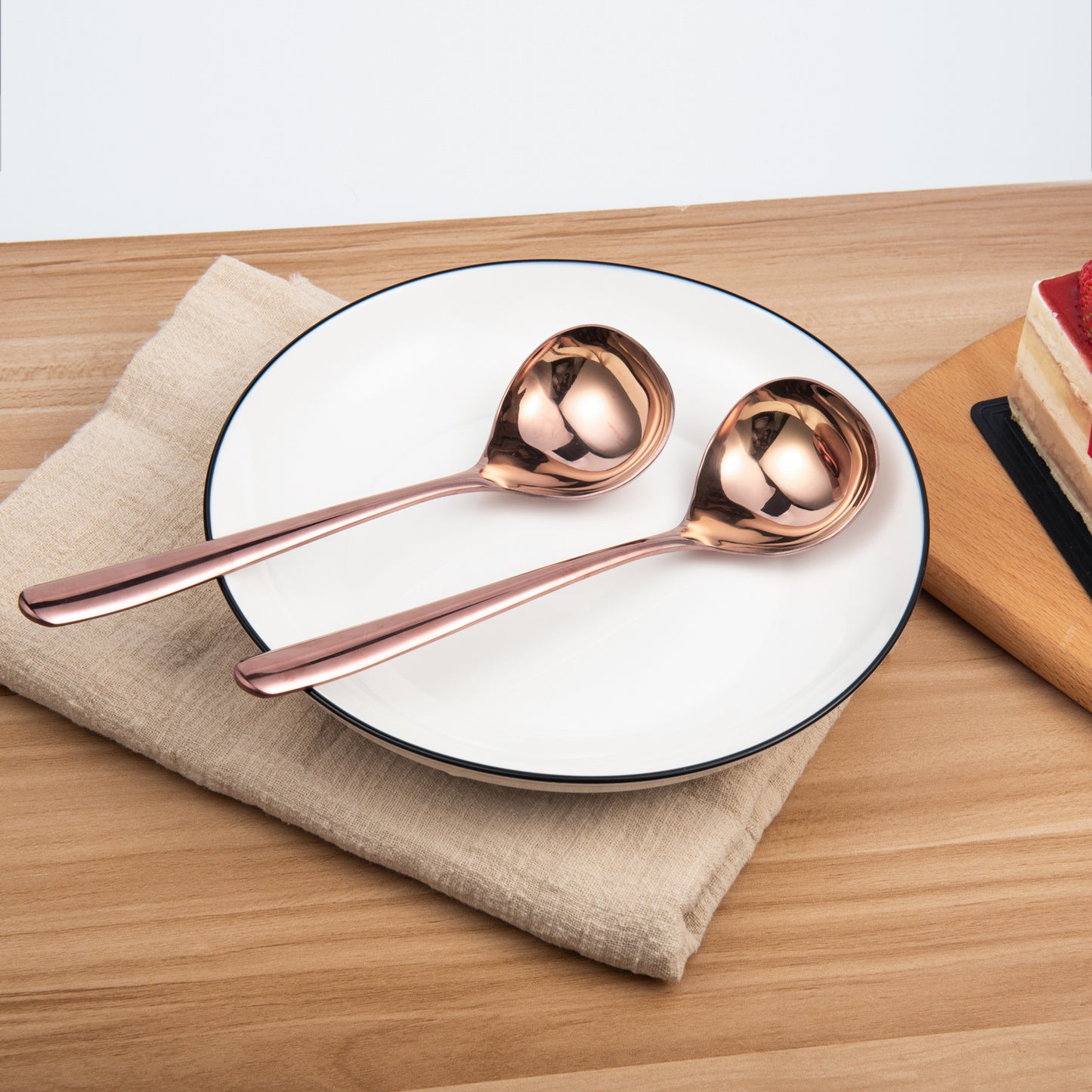Durable Rose Gold Sauce Ladle displayed on a dining plate showcasing its warm metallic tone