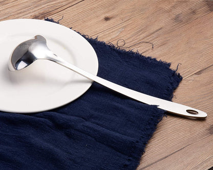 Stainless Steel Gravy Ladle with back design displayed upside down on a dining plate