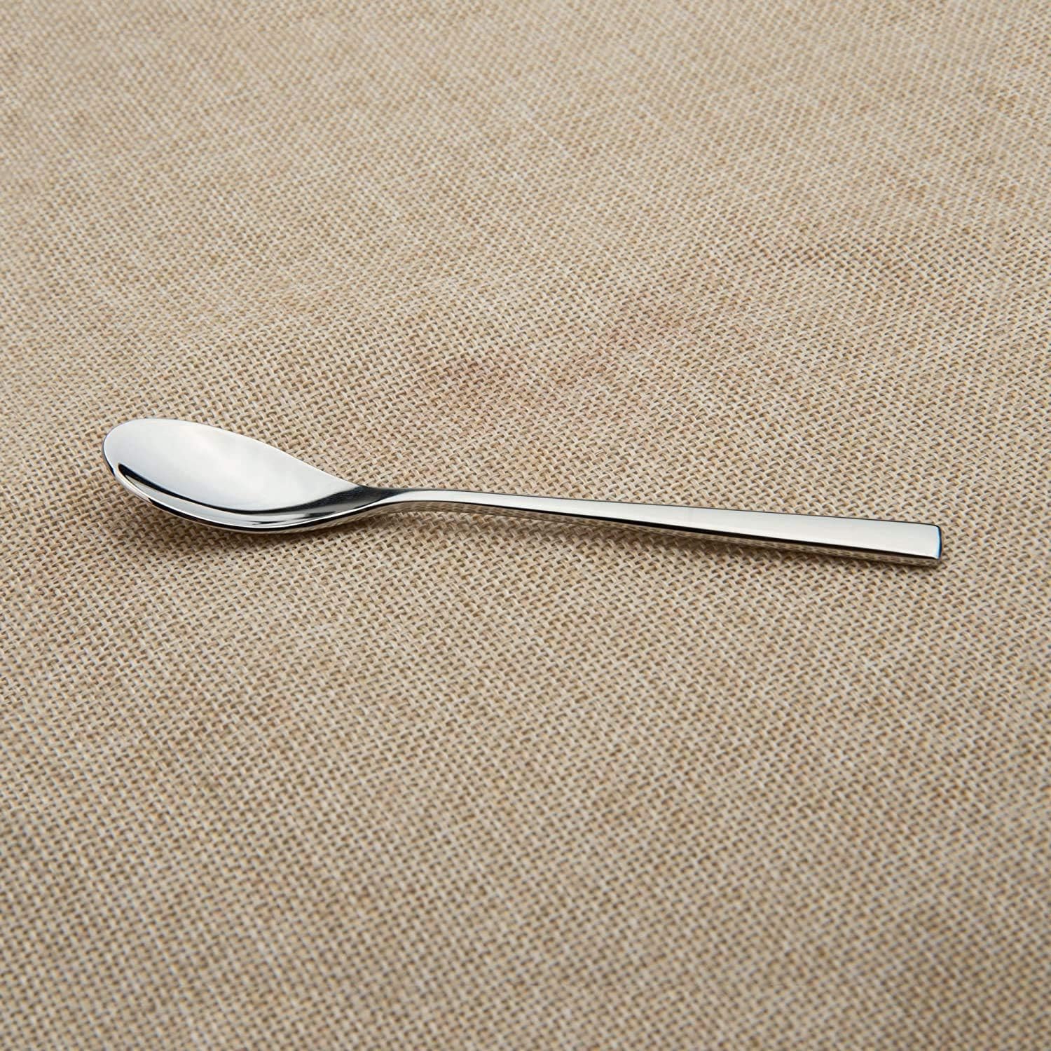 Mirror polished espresso spoons placed on a tablecloth, showcasing a sleek stainless steel design