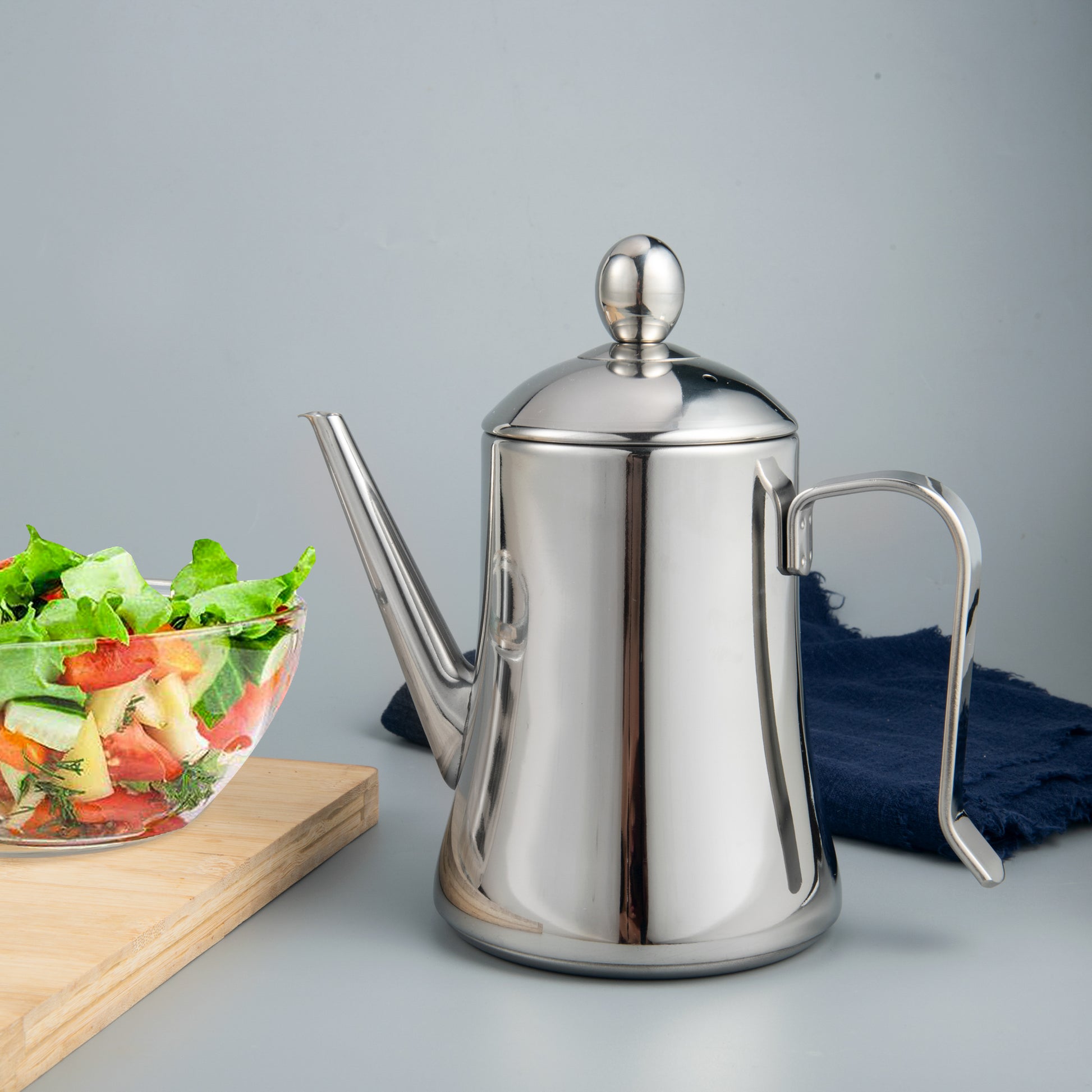 Olive Oil Dispenser placed beside salad on dining table for convenient dressing and serving