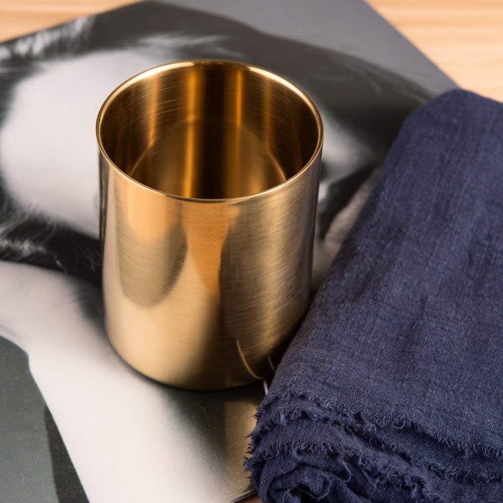Elegant gold pencil cup holder featuring a smooth polished stainless steel finish on a desk
