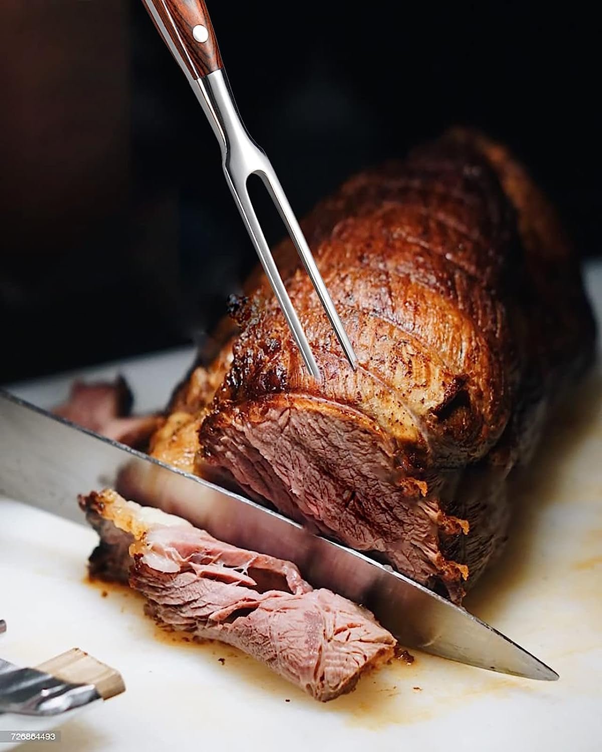Durable stainless steel carving fork with wooden handle holding roasted meat for carving