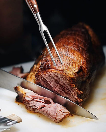 Durable stainless steel carving fork with wooden handle holding roasted meat for carving