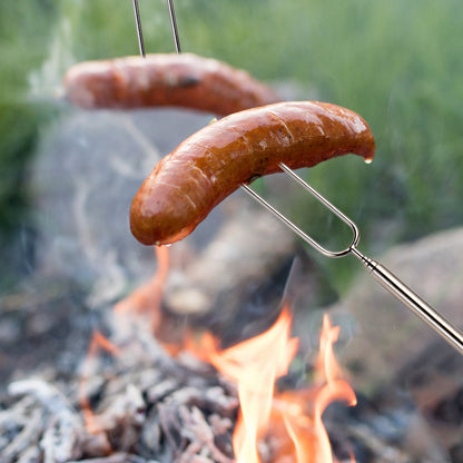 Stainless Steel Roasting Stick grilling a hot dog over an outdoor fire with forked tip design