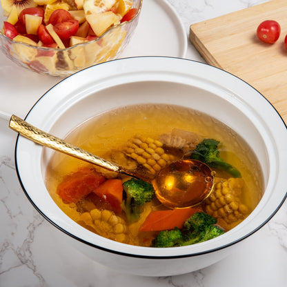 IMEEA gold stainless steel sauce ladle placed in a soup bowl