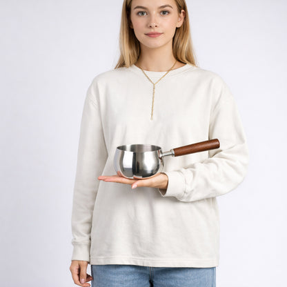 Milk pot placed on the palm, highlighting its compact size and design