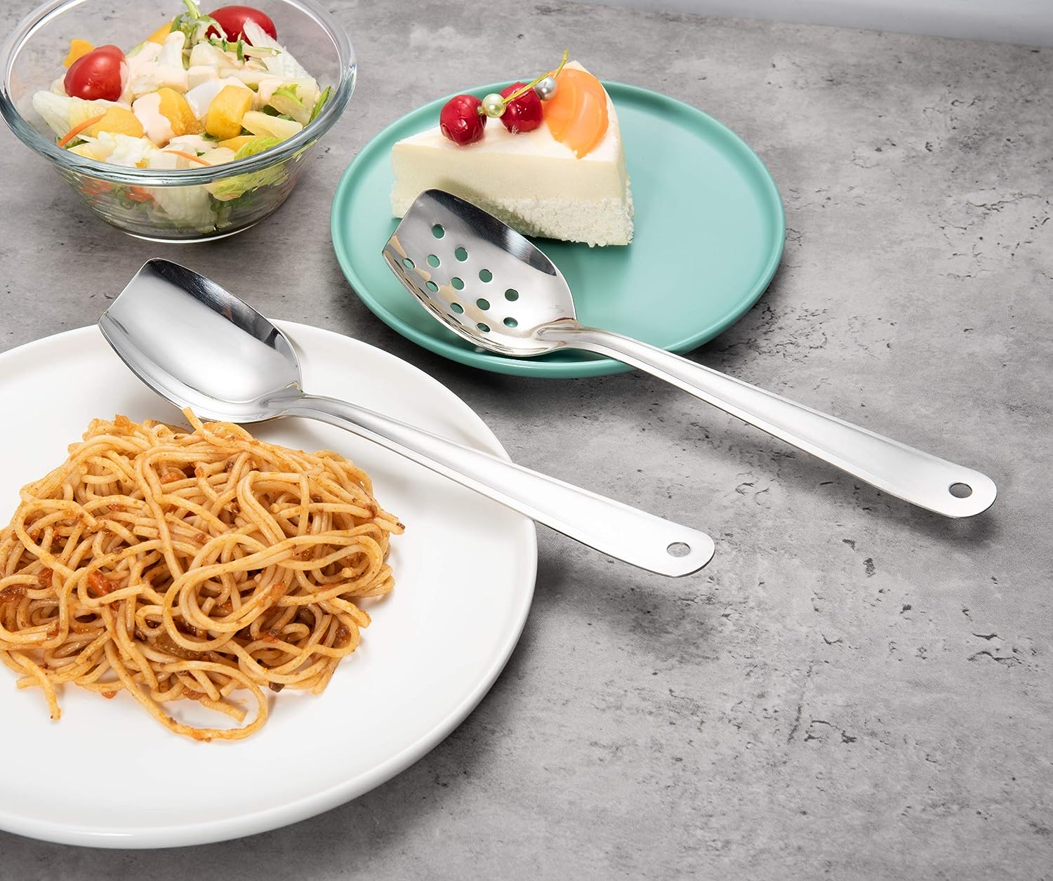 Smooth 18/8 Stainless Steel Flat Serving Spoon Set placed on a dining table beside food for serving meals