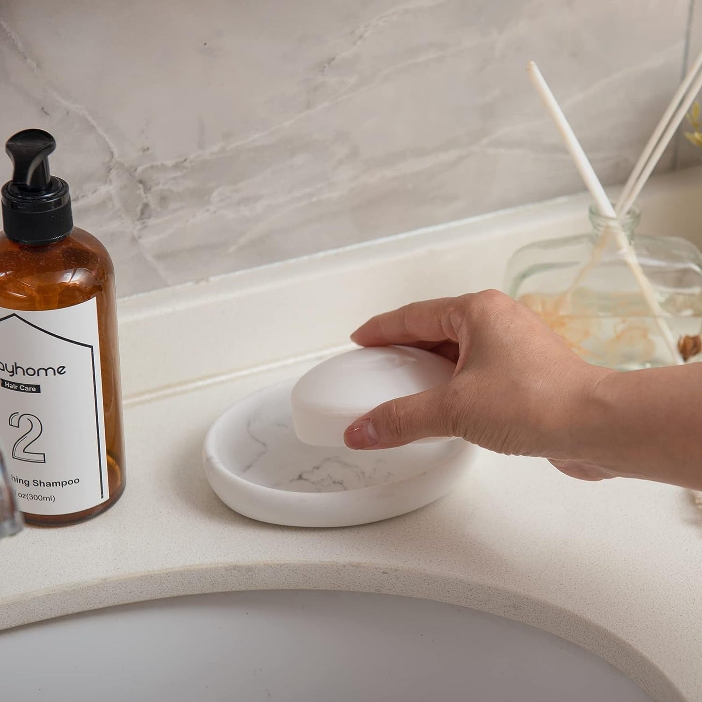 Marble Look Resin Soap Dish beside bathroom sink with hand picking up soap