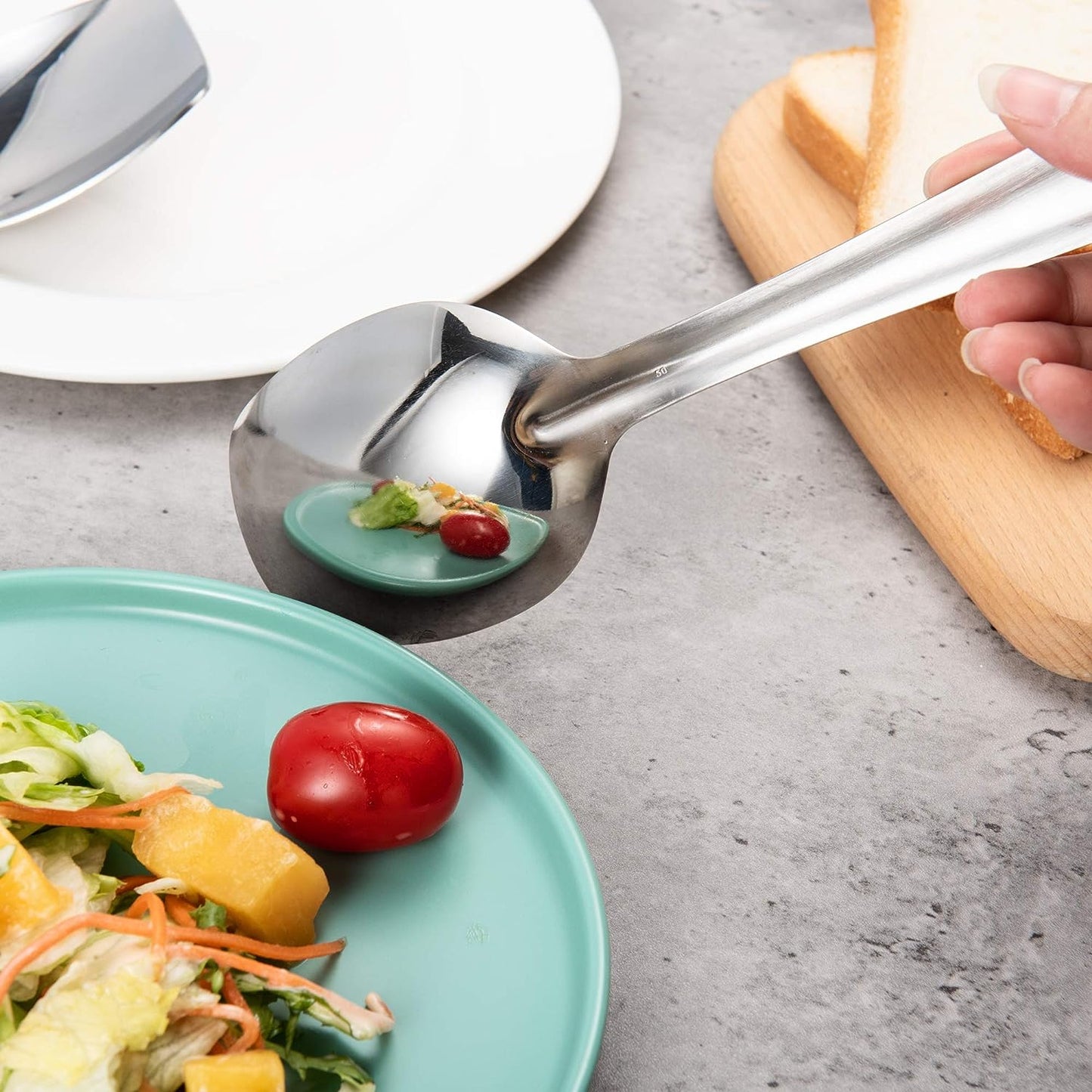Mirror Finish 18/8 Stainless Steel Serving Spoon with salad plate reflection visible on the polished surface