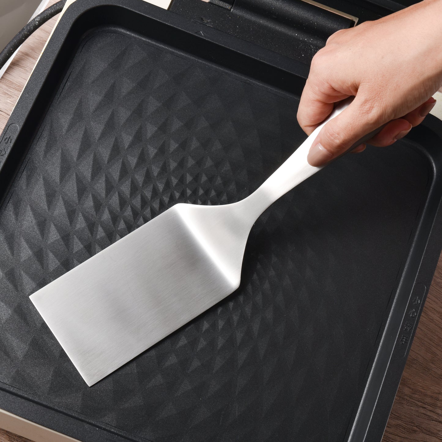 Polished Surface Stainless Steel Spatula held over a pan with a comfortable cooking grip