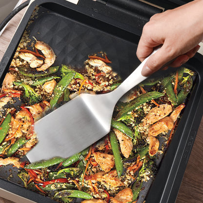 SUS304 Stainless Steel Solid Spatula used for stir frying food in a kitchen pan during cooking