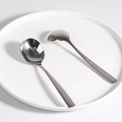 Compact Stainless Steel Soup Spoon front and back view on a plate