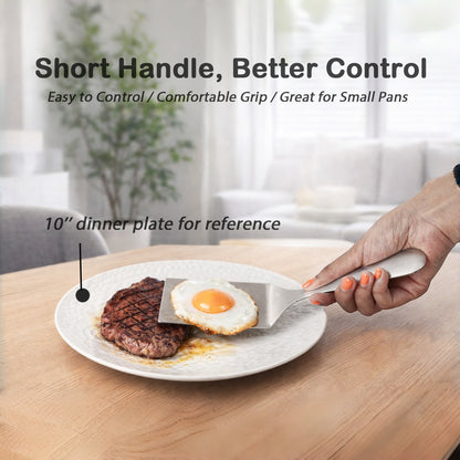 Comfortable Grip SUS304 Stainless Steel Spatula transferring a fried egg to a steak plate with short handle design