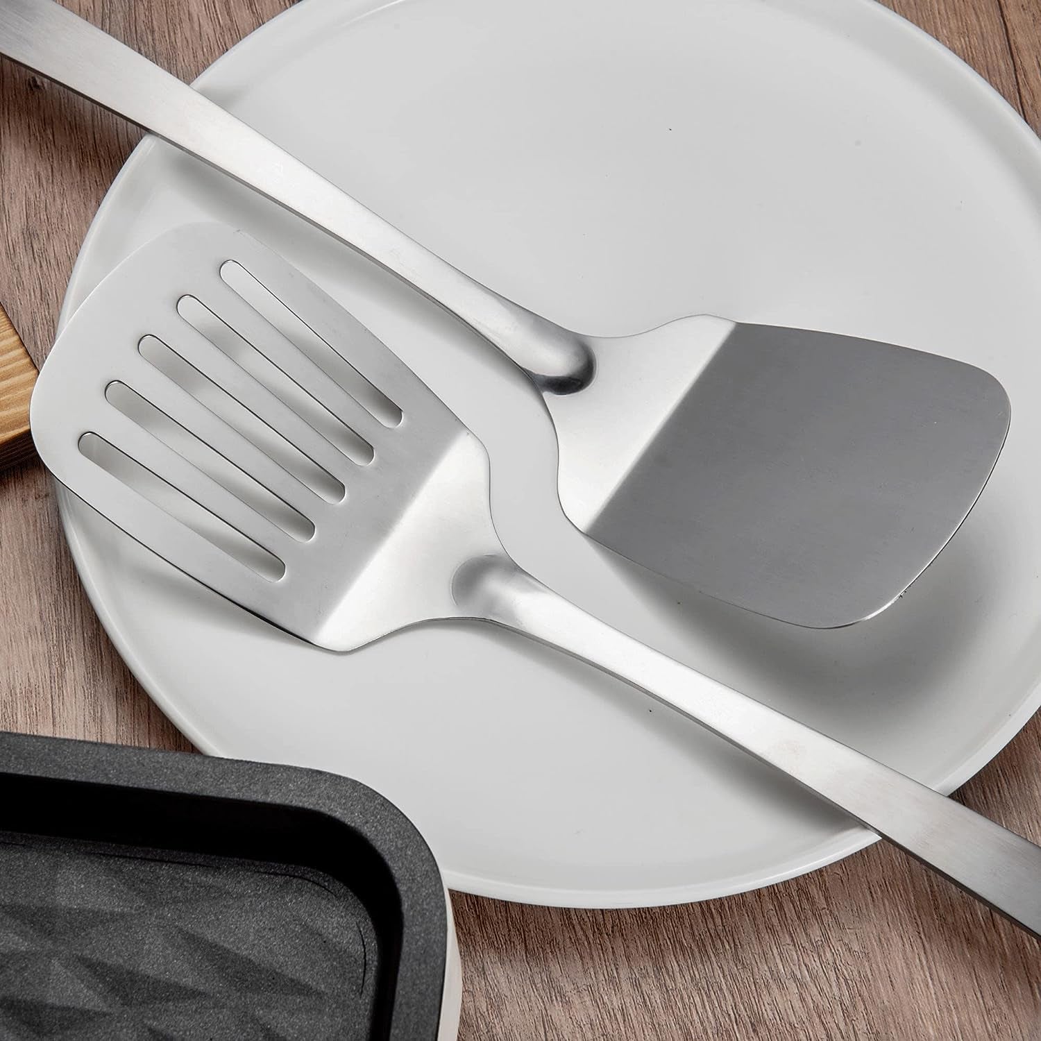Stainless Steel Kitchen Spatula Set 13.5 inch displayed close-up with turner heads placed on a plate, showcasing the solid and slotted spatula designs