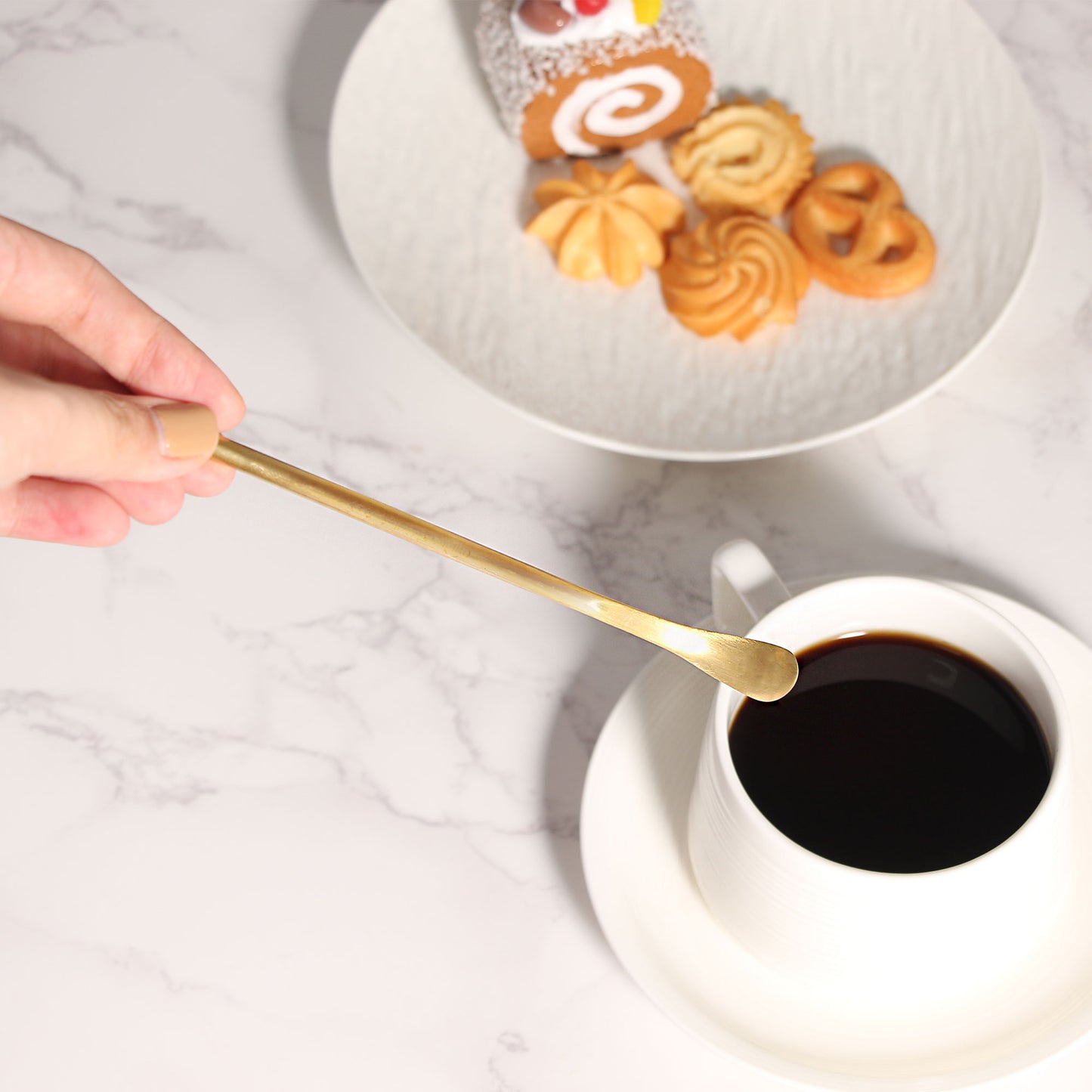 Elegant Gold Stainless Steel Stir Spoons displayed beside coffee and desserts with a refined table arrangement