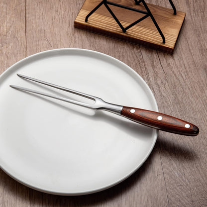 MEEA stainless steel carving fork with wooden handle placed on a plate