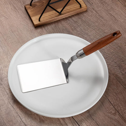 Minimalist Solid Stainless Steel Turner Spatula with Wood Handle placed on a round plate