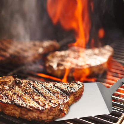 Grilling Solid Stainless Steel Turner Spatula with Wood Handle lifting steak from a grill