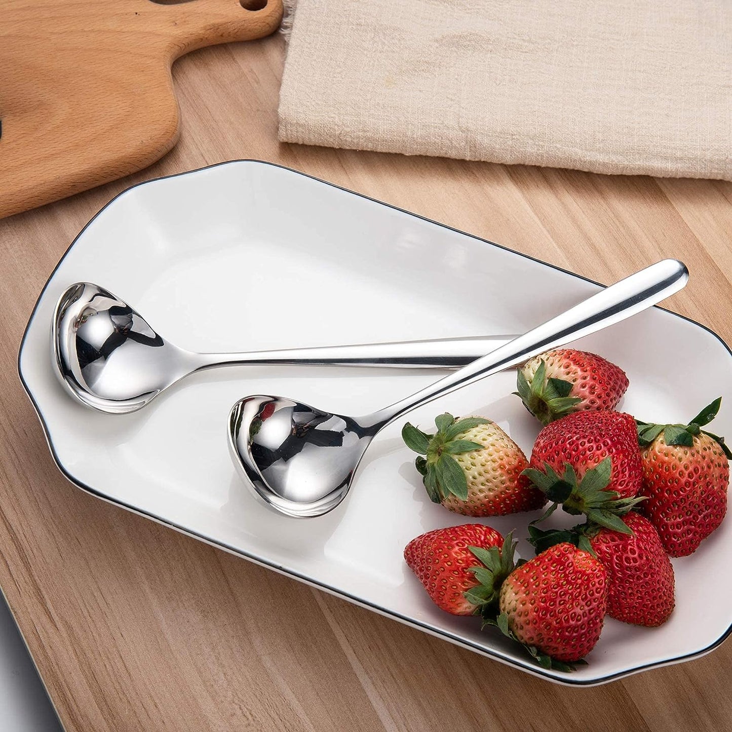 IMEEA SUS304 Stainless Steel Gravy Ladles placed on a plate with strawberries in a home dining setting