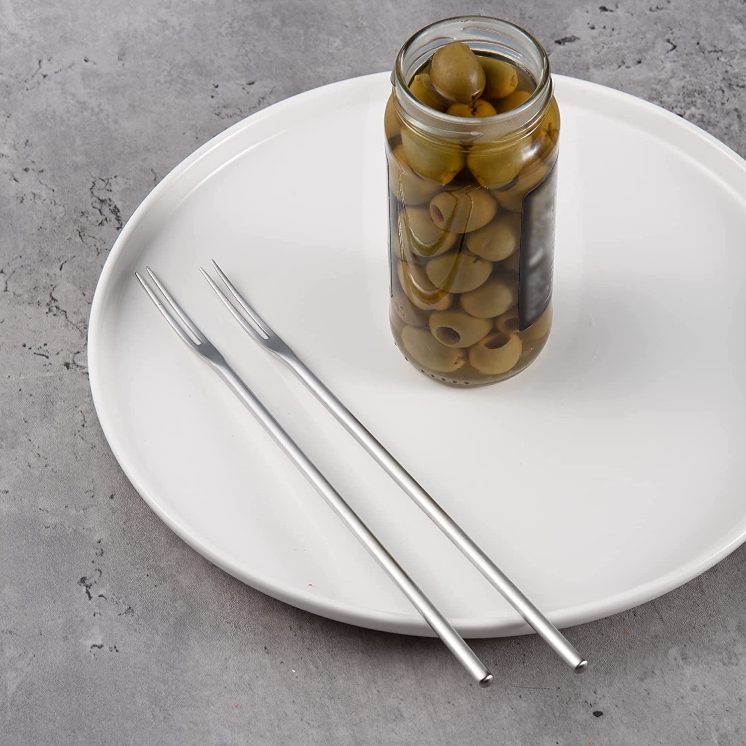 SUS304 Stainless Steel Olive Fork with Long Handle placed beside an olive jar