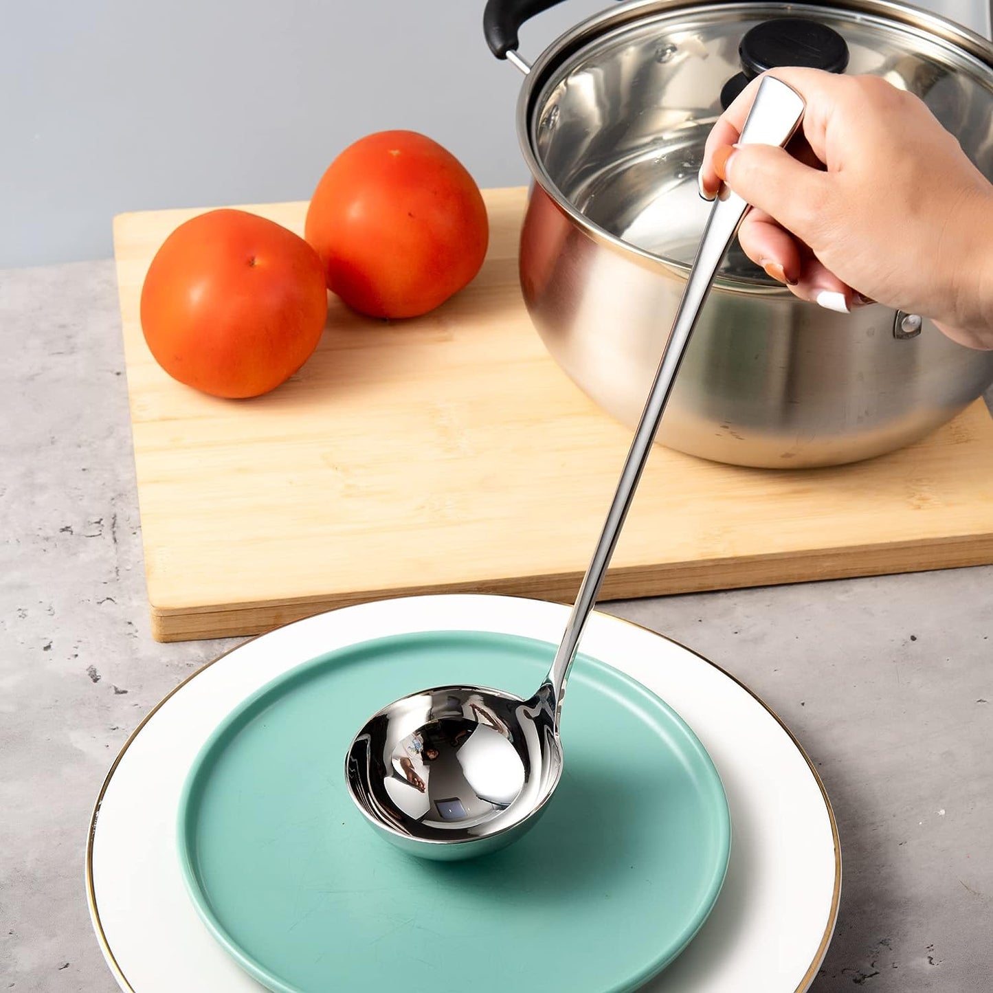 Elegant Stainless Steel Soup Ladle with a deep bowl and mirror finish placed on a serving plate
