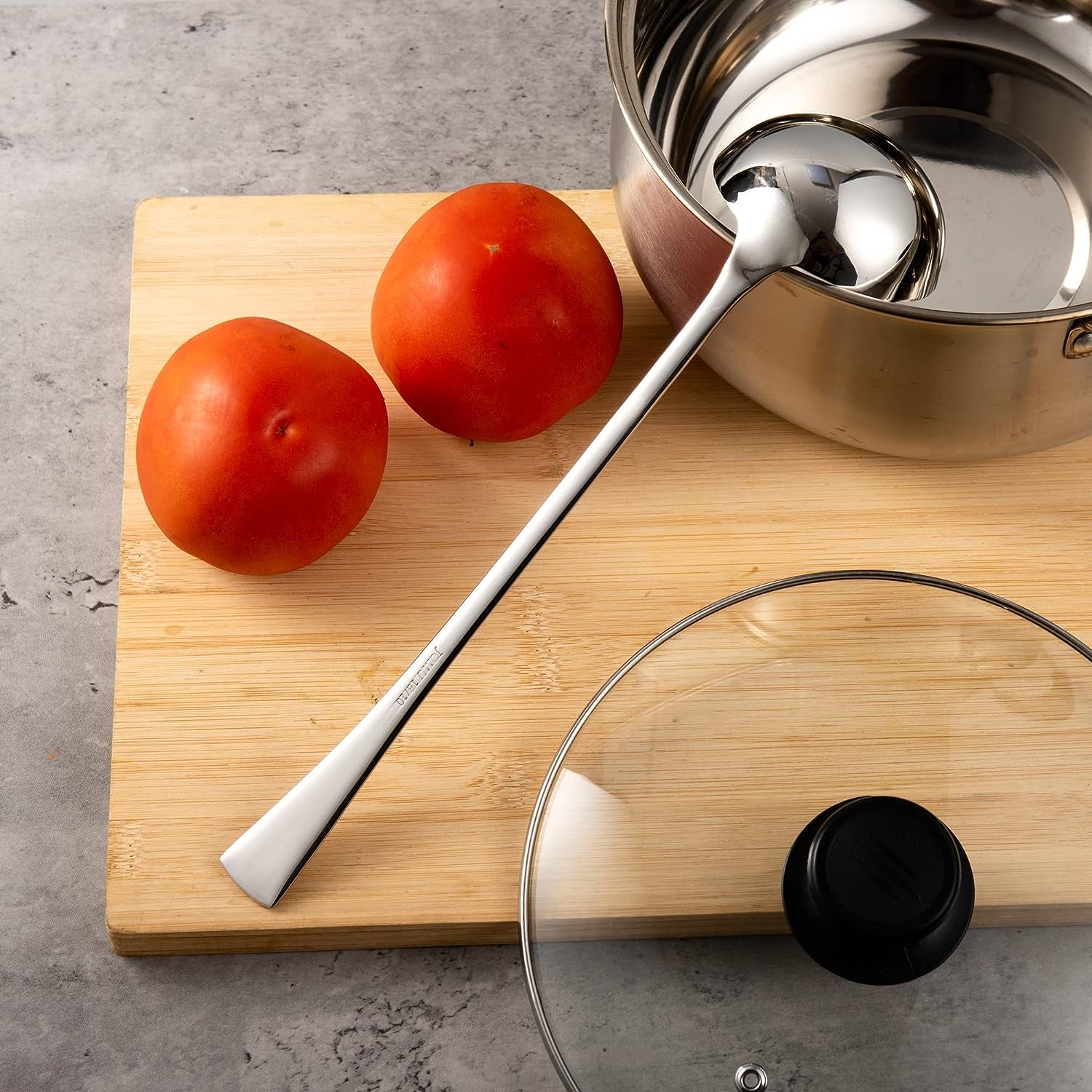 Stainless Steel Soup Ladle placed in a cooking pot on a cutting board