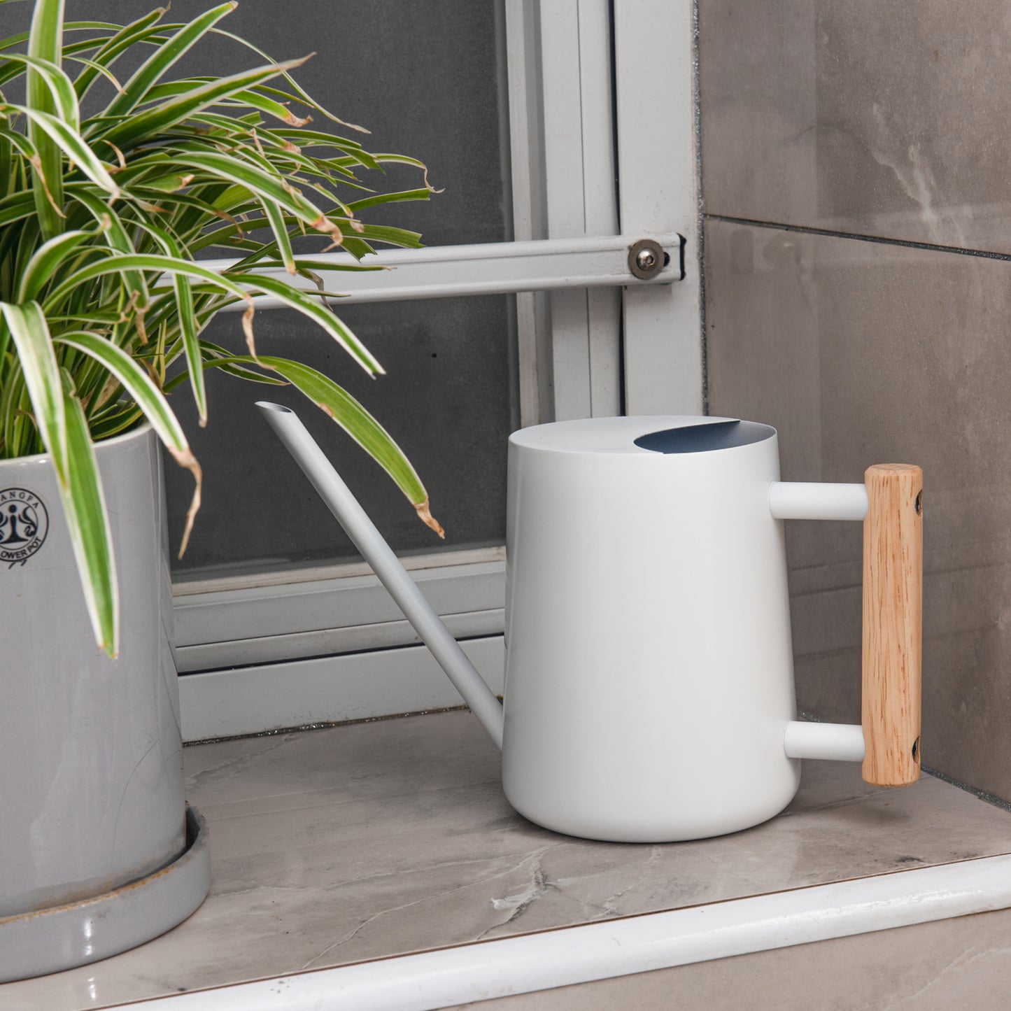 Indoor Plant Watering Can in White Stainless Steel with Wooden Handle on windowsill