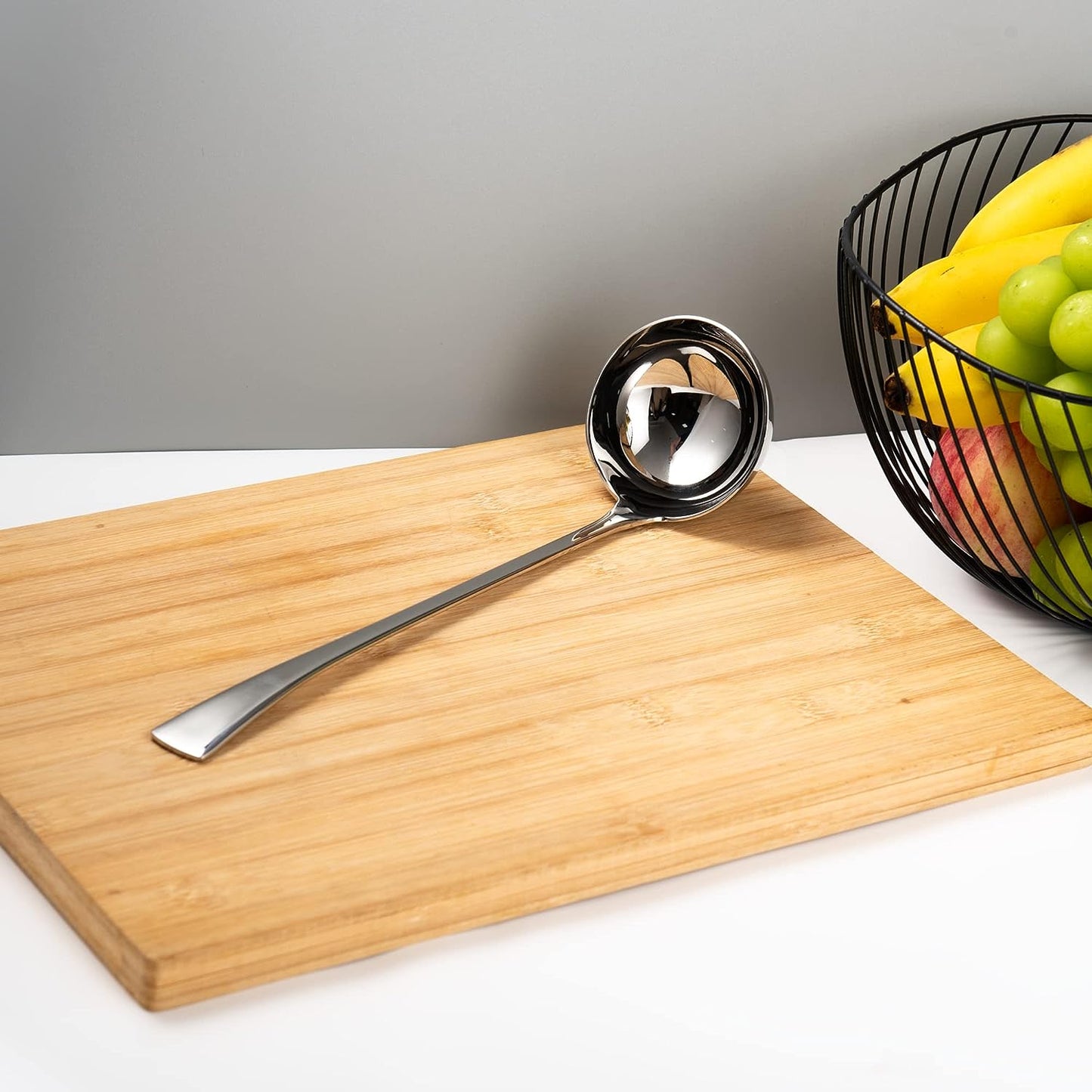 Stainless Steel Soup Server placed on a cutting board for a clean kitchen presentation