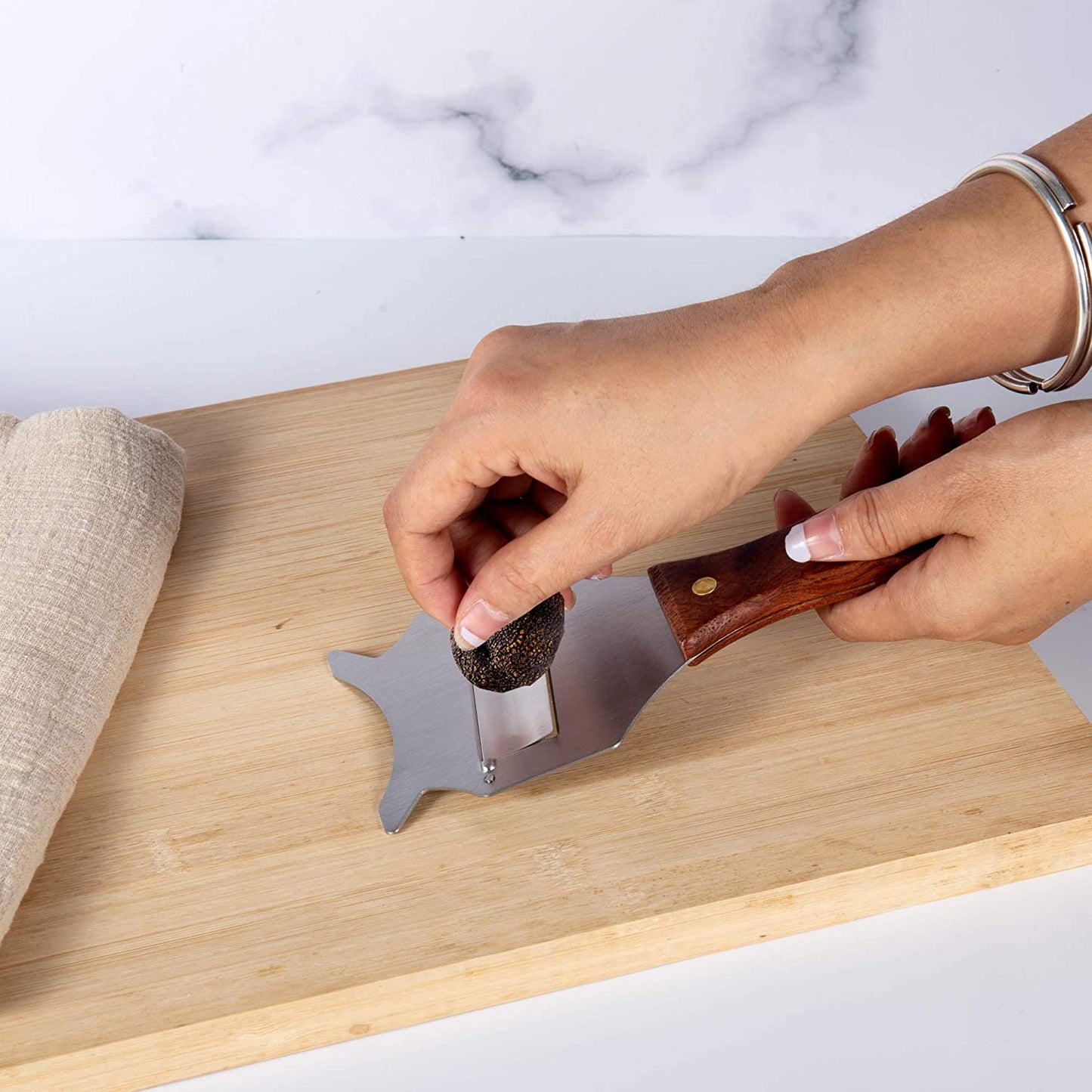 Stainless Steel Truffle Slicer shaving truffles on a kitchen cutting board