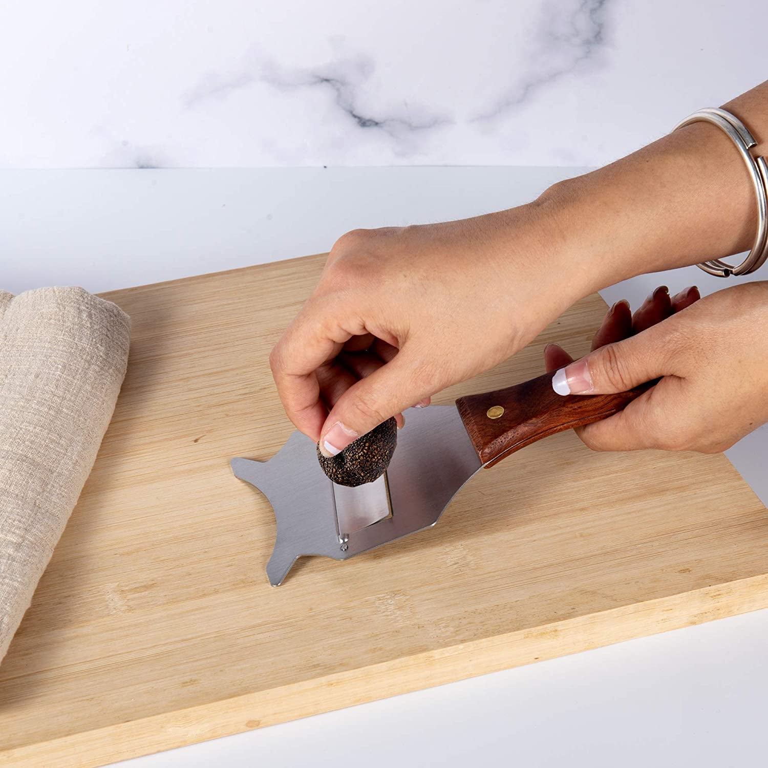 Stainless Steel Truffle Slicer shaving truffles on a kitchen cutting board