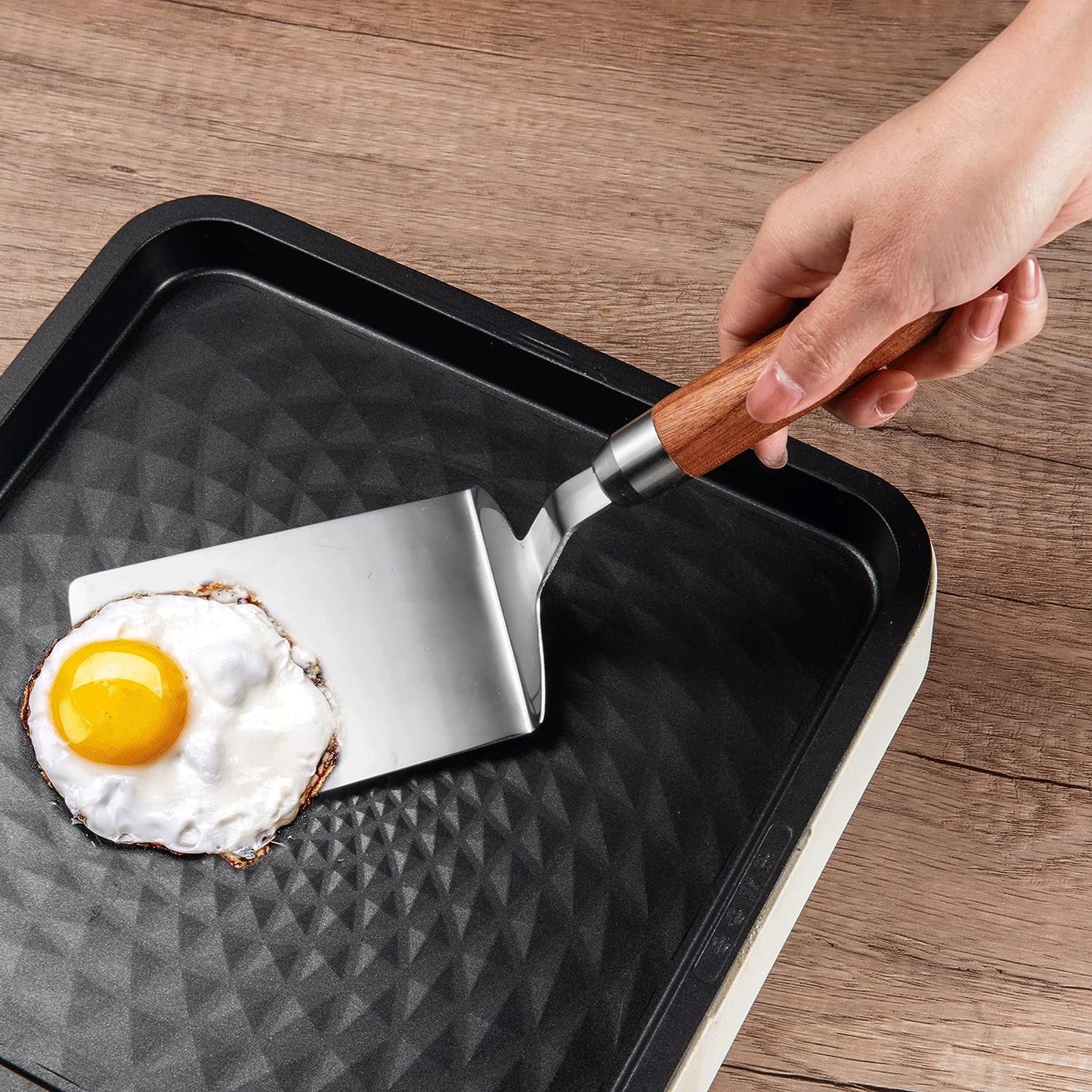 IMEEA Stainless Steel Turner Spatula with Wood Handle flipping egg on a frying pan